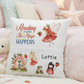 A personalized white throw pillow with whimsical fairy and cottage illustrations, featuring the text 'Reading is when The Magic HAPPENS' and the name 'Lottie', styled on a bed in a soft pink bedroom setting.
