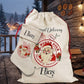 A personalized Christmas Santa sack and matching stocking set displayed on a rustic wooden porch. The cream-colored fabric sack features a red circular stamp design with an illustration of Santa Claus and the text 'North Pole Delivery Services' and the name 'Elias'.