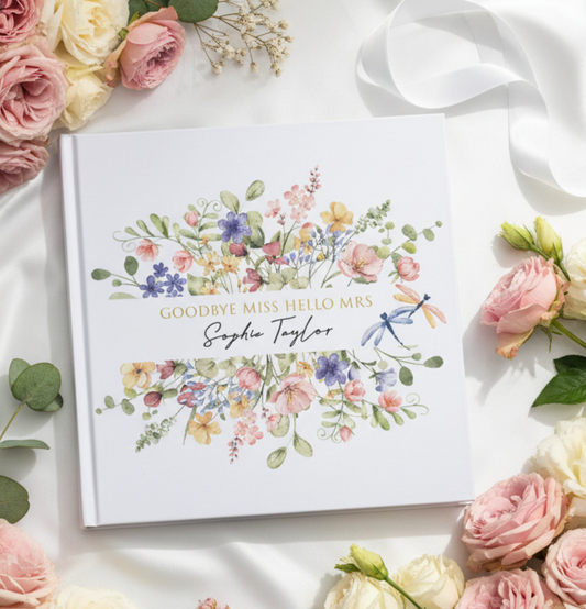 Greeting card with floral design and text on a marble surface with flowers and ribbon.
