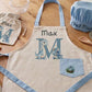 Children's apron and chef hat set with 'Max' on a kitchen counter