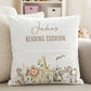 A personalized white throw pillow with a watercolor safari animal design and the text 'Jaden's READING CUSHION', displayed on a beige sofa.