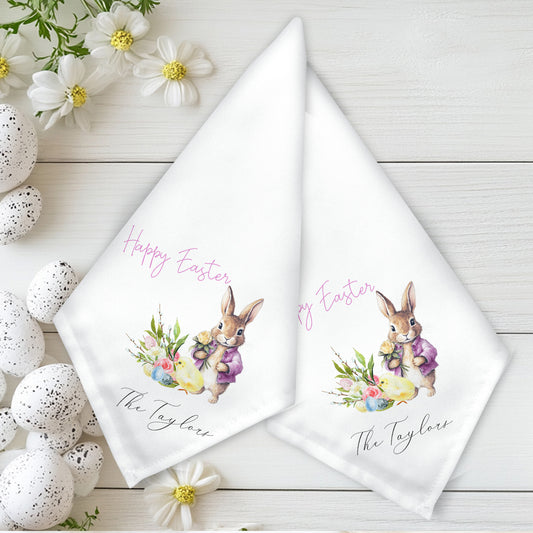 Two Easter-themed napkins with bunnies and flowers on a wooden surface with decorative eggs and flowers.
